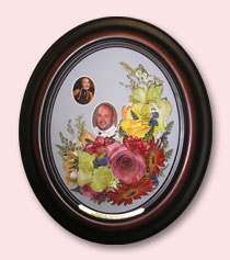 multi-colored flowers preserved with photos of nephew in sleek brown oval frame with engraving