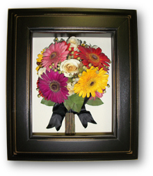 bridal bouquet of multi colored daisies preserved in a shadow box