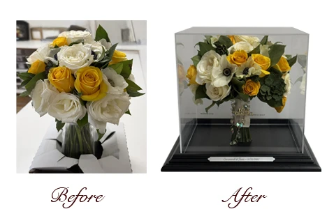 Wedding bouquet of yellow and white roses preserved in a clear box with wooden base