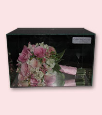 pink bouquet of roses with pink ribbon preserved in glass box