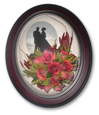 medium size brown oval frame with preserved wedding bouquet and photo of bride and groom