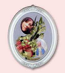memorial flowers preserved around photos of a woman and of Mary encased in a white frame