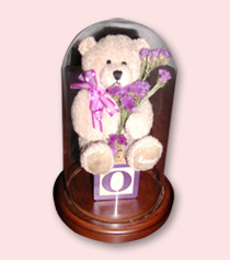 baby block and teddy bear with preserved flowers displayed in a table dome