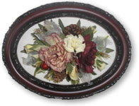 red and cream funeral flowers preserved in brown ornate frame